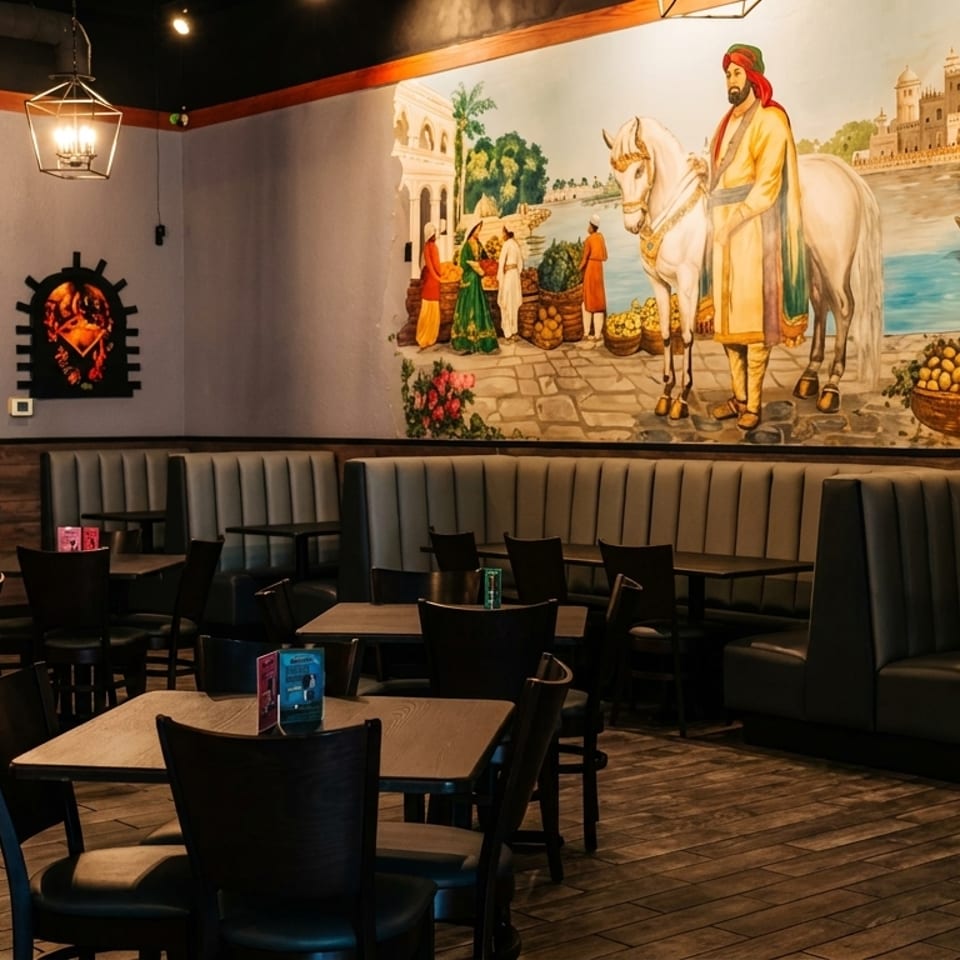 Restaurant interior with booths, tables, and a large mural depicting a man on a horse.
